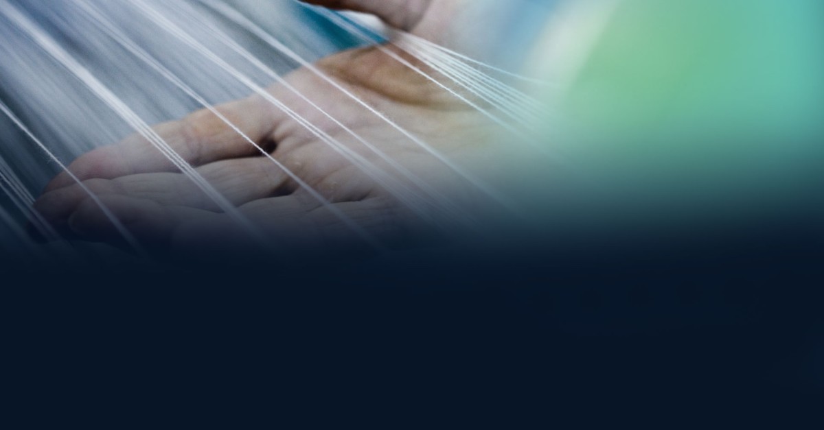 Main d'expert tenant des fibres de tissus techniques illustrée du logo de SUBRENAT, fabricant et fournisseur français de textiles techniques sur mesure